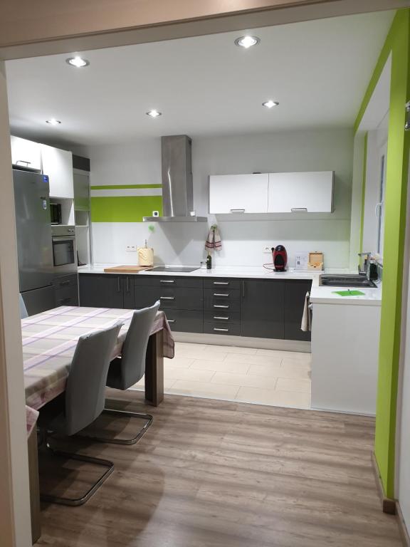a kitchen with a table and a kitchen with green at Enjoy Valencia in Valencia