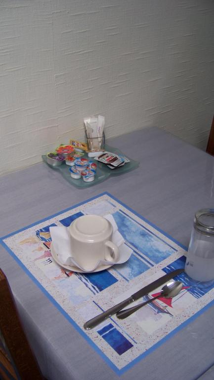 a table with a plate and a bowl and spoon at Hotel Du Port in Concarneau