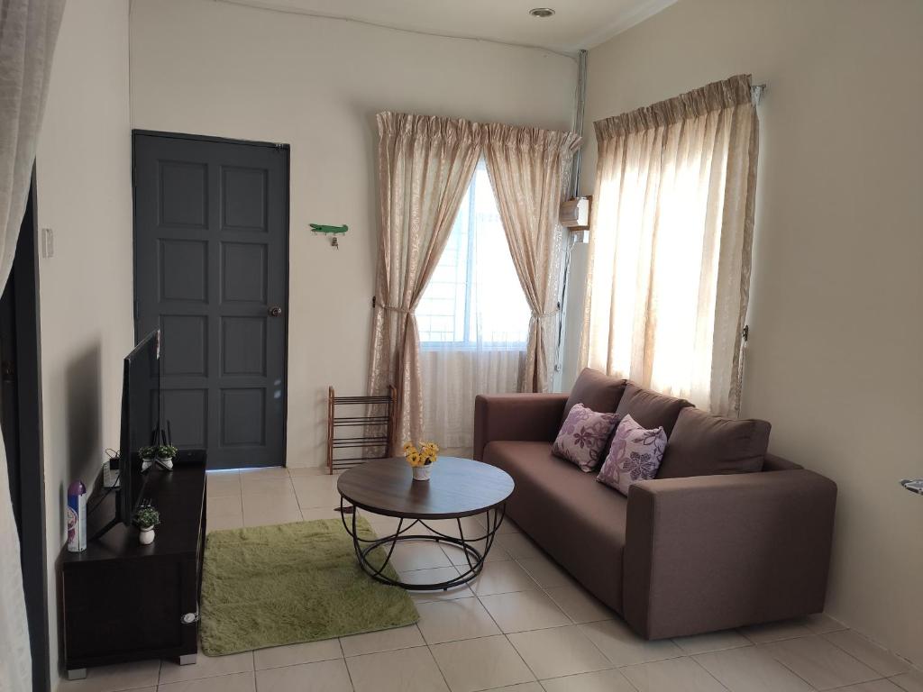 uma sala de estar com um sofá e uma mesa em Homestay at Petrajaya,Kuching em Kuching