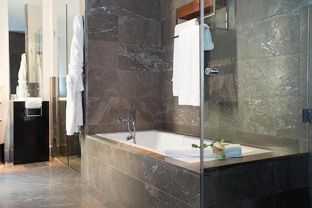 a bathroom with a bath tub and a shower at Hospes Palacio del Bailio, a Member of Design Hotels in Córdoba