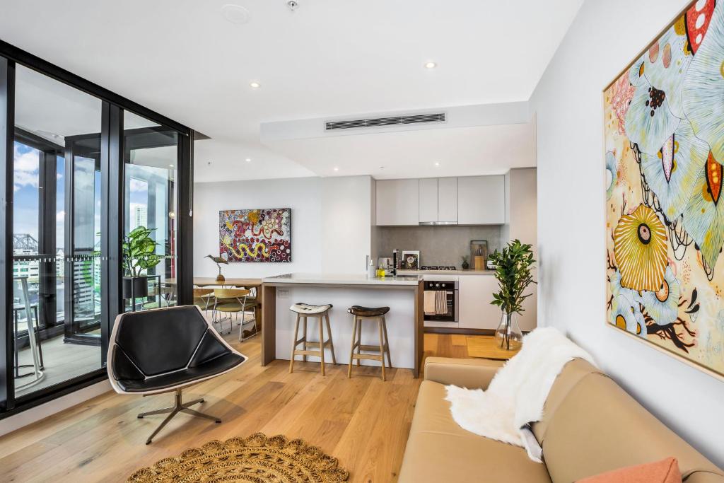una cucina e un soggiorno con divano e bancone di KOZYGURU FORTITUDE VALLEY DESIGNER GRADE 2 BED APT FREE PARKING QFV179-1401 a Brisbane