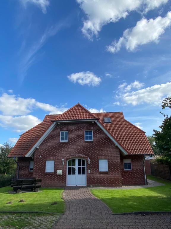 a brick house with a bench in front of it at Ferienwohnung am Deichweg in Cappel-Neufeld