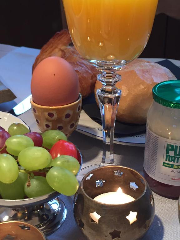 a table with a plate of bread and a glass of juice at B&B Bella en Basiel in Bruges