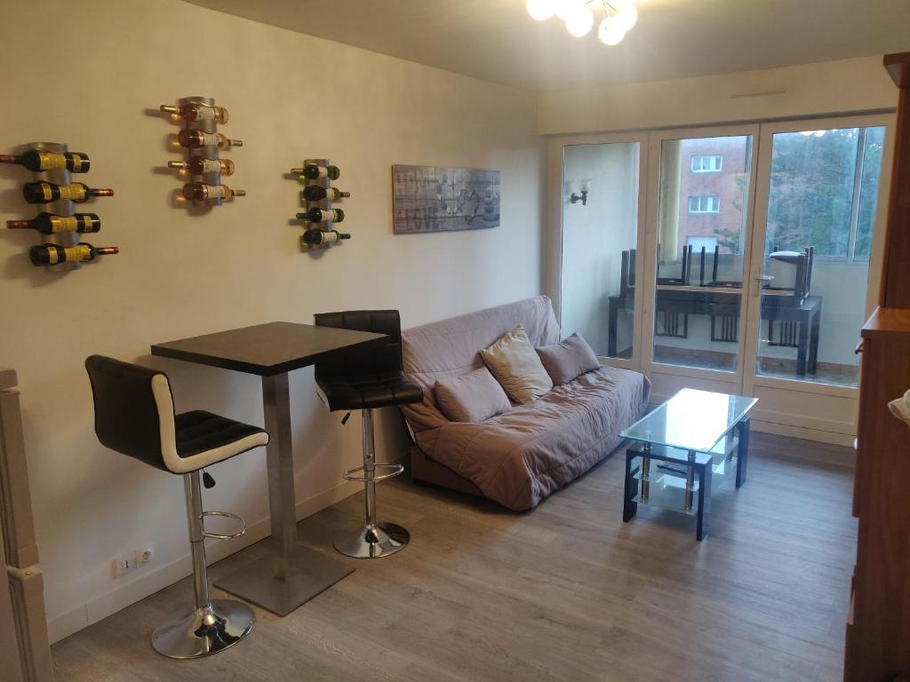 un salon avec un canapé et une table dans l'établissement Appartement F3 Cabourg près plage hippodrome centre-ville, à Cabourg