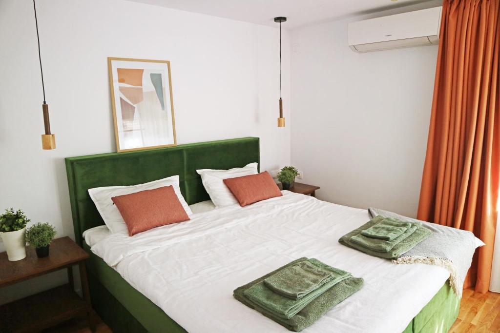 ein grün-weißes Bett mit zwei Kissen darauf in der Unterkunft Modern Cozy Apartment - NEW in Kjustendil