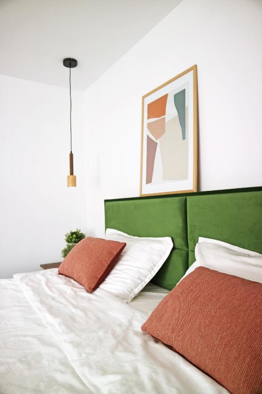 a bedroom with a green and white bed with two pillows at Modern Cozy Apartment in Kyustendil