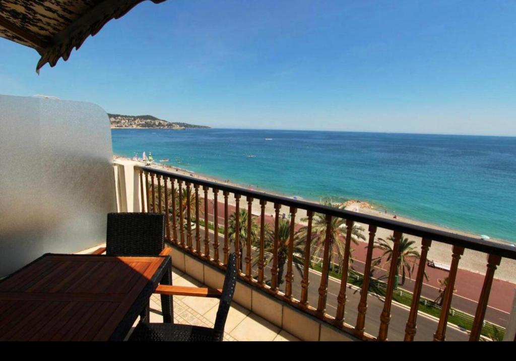 Appartement avec vue mer sur la Promenade des Anglais في نيس: شرفة مطلة على الشاطئ والمحيط