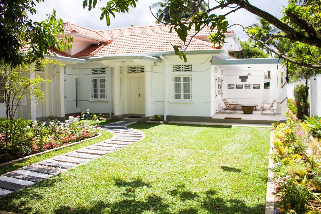 a white house with a green yard at Villa Lewis in Badulla