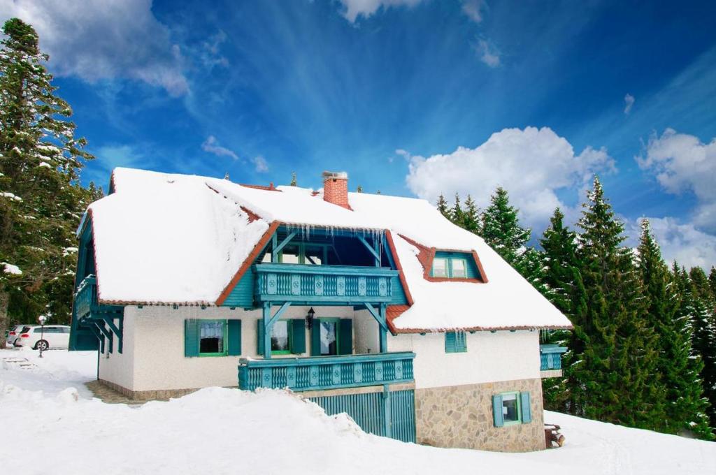 a house with snow on the roof at Apartma Ajdovka Rogla in Vitanje