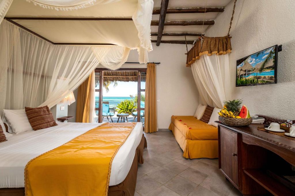 een slaapkamer met een groot bed en een balkon bij Karafuu Beach Resort & Spa in Pingwe