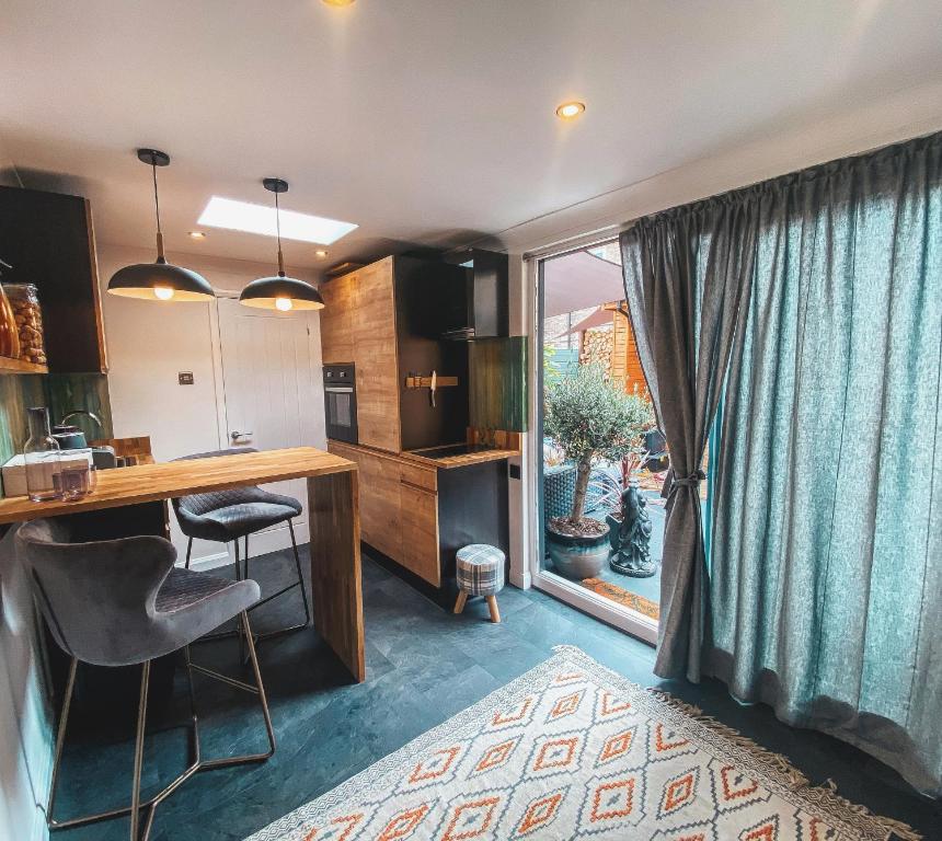 a kitchen with a desk and chairs and a window at Cosy Studio in Newmarket