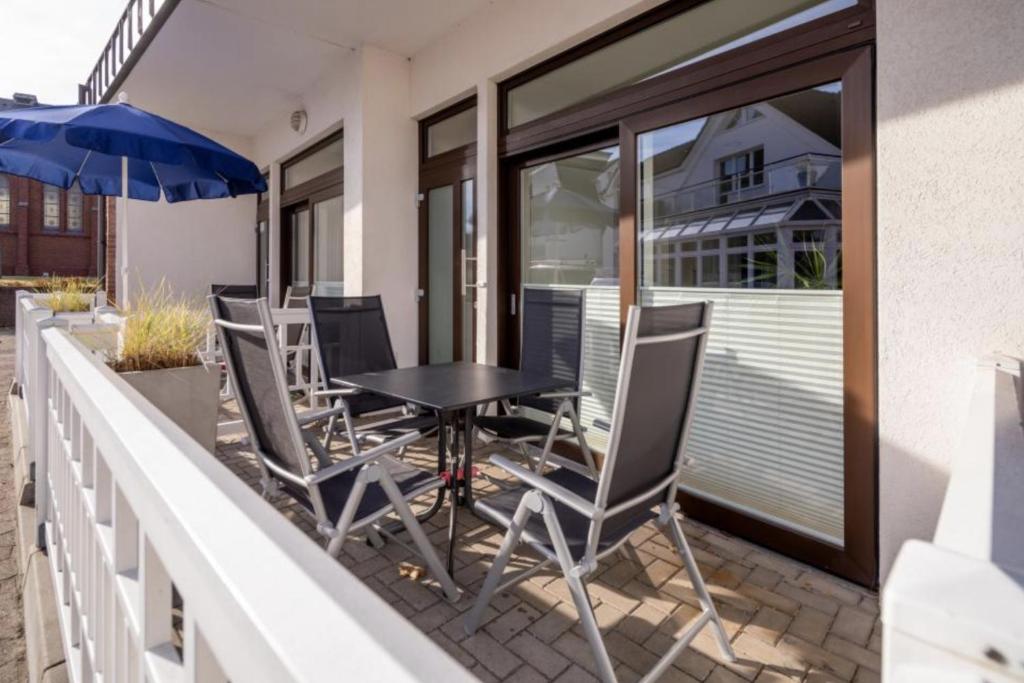 a patio with chairs and a table and an umbrella at Norderneytraum Kampstr. Wohnung 1 in Norderney