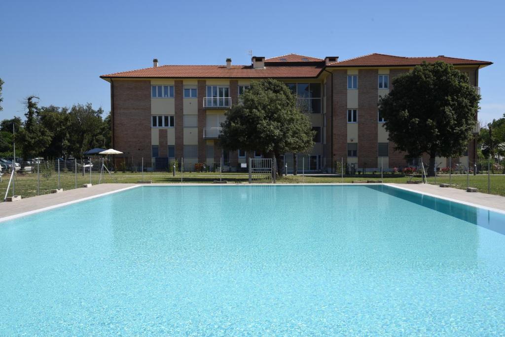 uma grande piscina em frente a um edifício em Residence Il Piviere app 7 with private garden em Calambrone