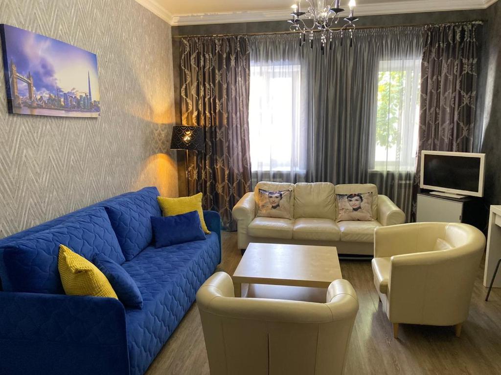 a living room with a blue couch and chairs at Apartment na Kirova 37 in Pyatigorsk