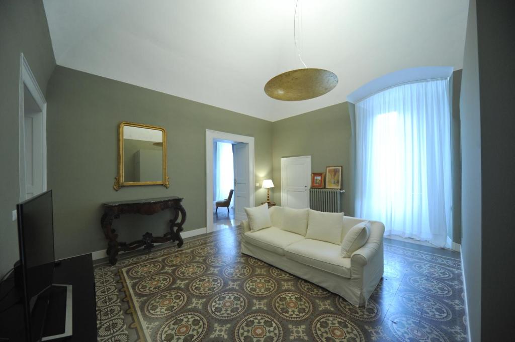 ein Wohnzimmer mit einem weißen Sofa und einem Spiegel in der Unterkunft Palazzo Ietri Corso Vittorio Emanuele ROOMS in Bari