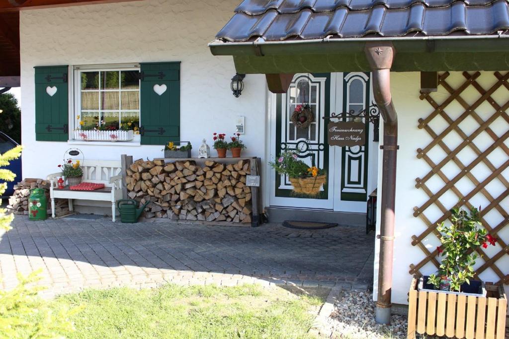 een huis met een bank en een stapel brandhout bij Ferienwohnung Haus Nadja in Winterberg