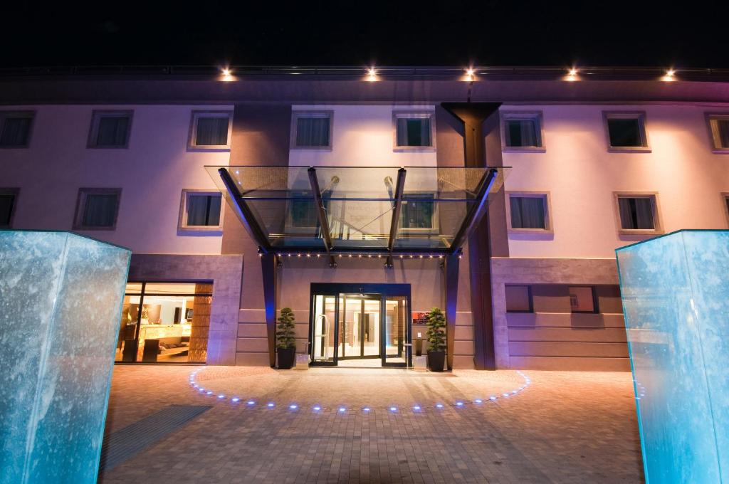 a large building with a glass entry way at Winter Garden Hotel Bergamo Airport in Grassobbio