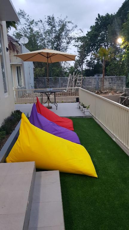 a patio with a table and a yellow and rainbow flag at Villa Allesha Batu in Batu
