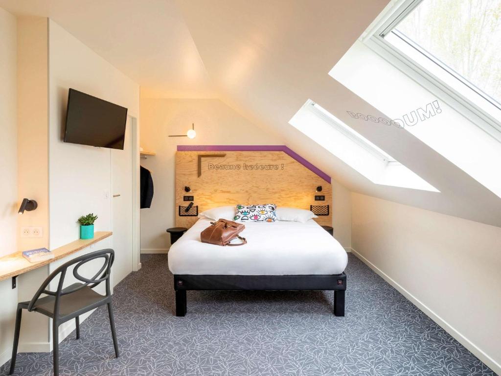 a bedroom with a bed and a chair in a attic at greet Hotel Beaune in Beaune