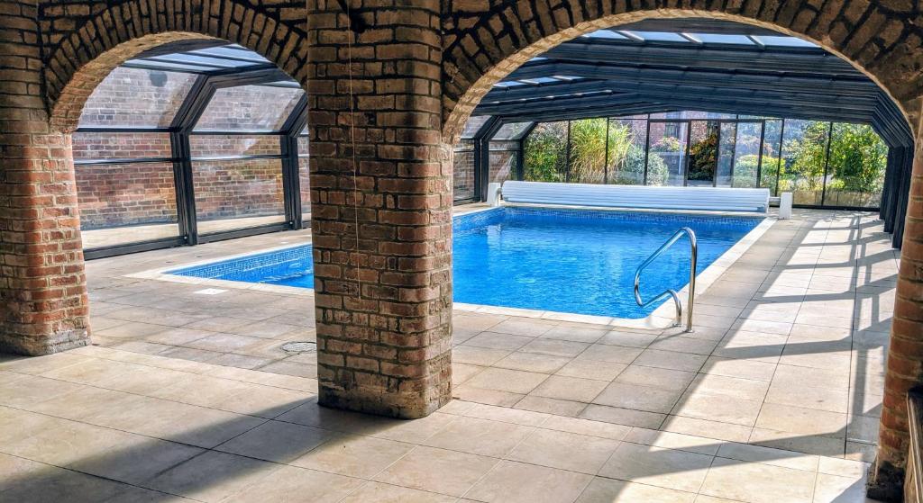 a swimming pool in a brick building with an archway at Covenham Holiday Cottages in Covenham