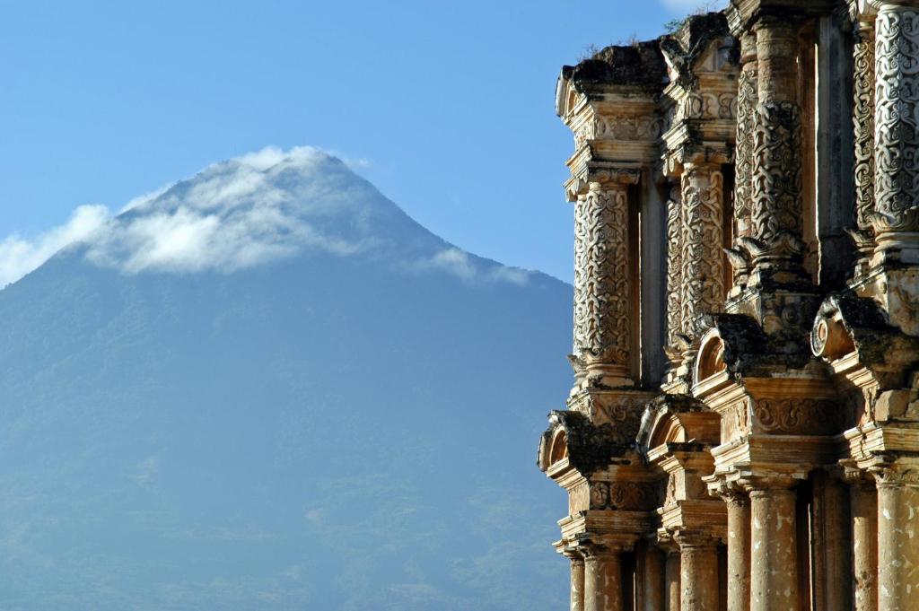 a building with a mountain in the background at Casa Serenidad in Antigua Guatemala