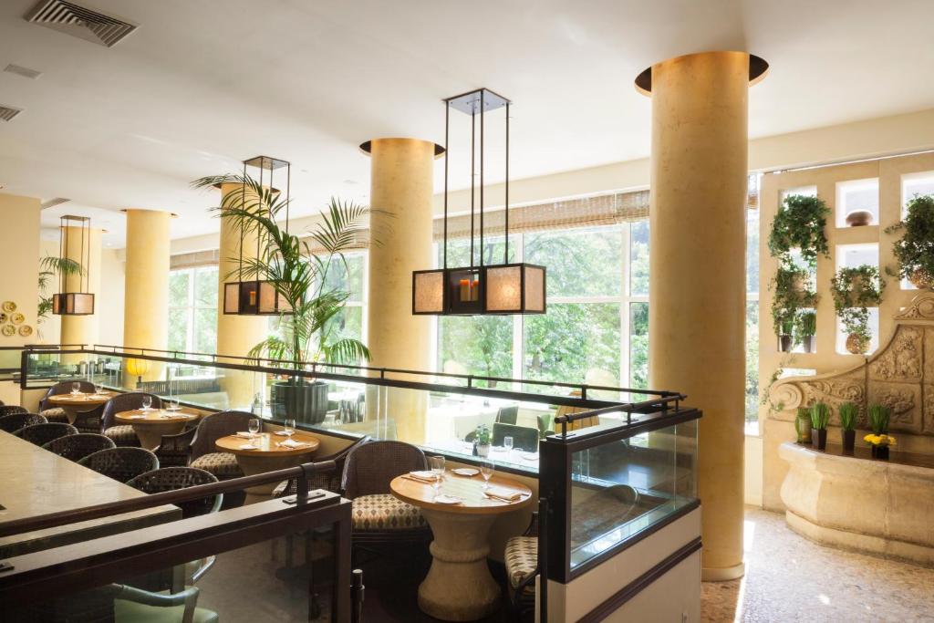 a restaurant with tables and chairs and windows at The Rittenhouse Hotel in Philadelphia