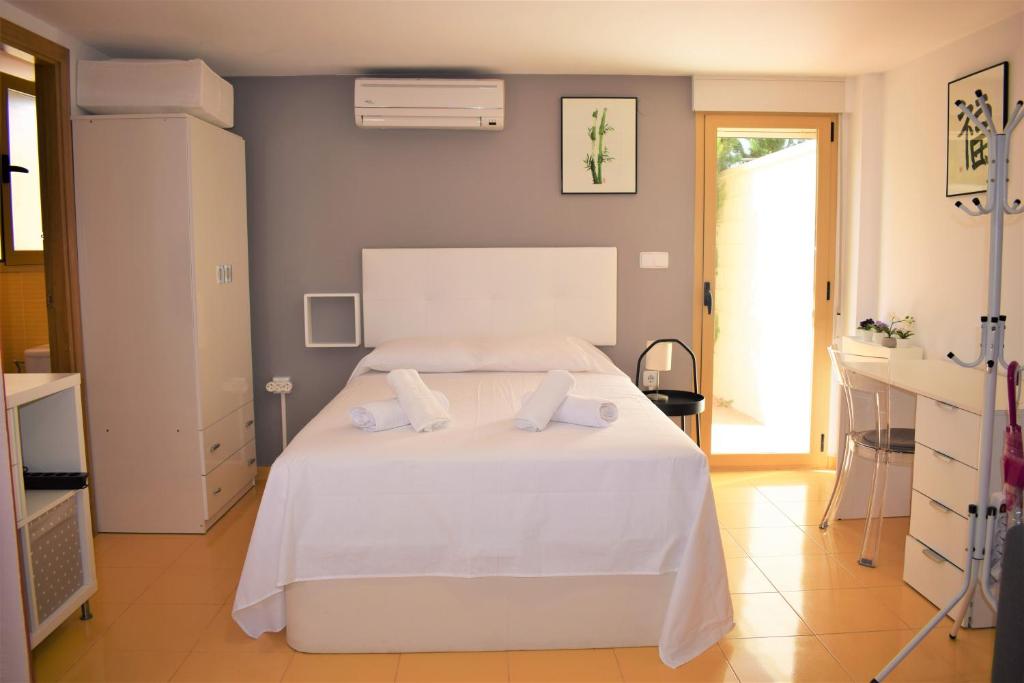 a bedroom with a white bed with two pillows on it at Anacasa Avinyo Sector 5 AP120 in Oliva