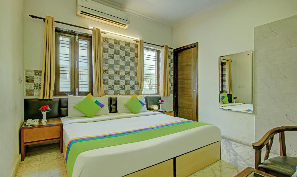 a bedroom with a large bed and a bathroom at Itsy By Treebo - Swastika Inn in Noida