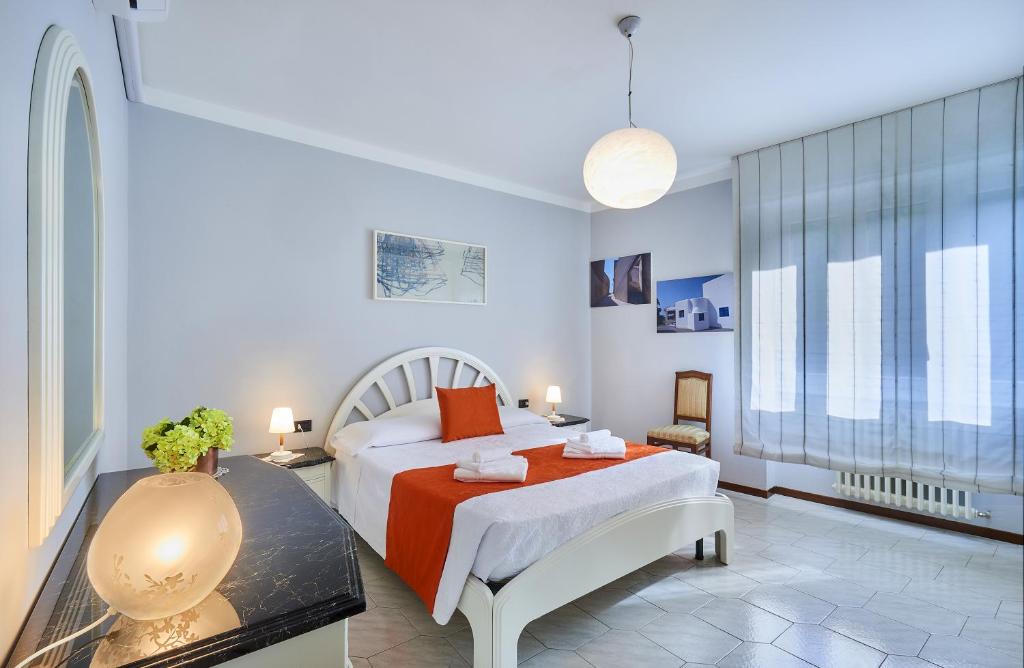 a white bedroom with a bed and a table at Apartment Varenna Dream in Varenna