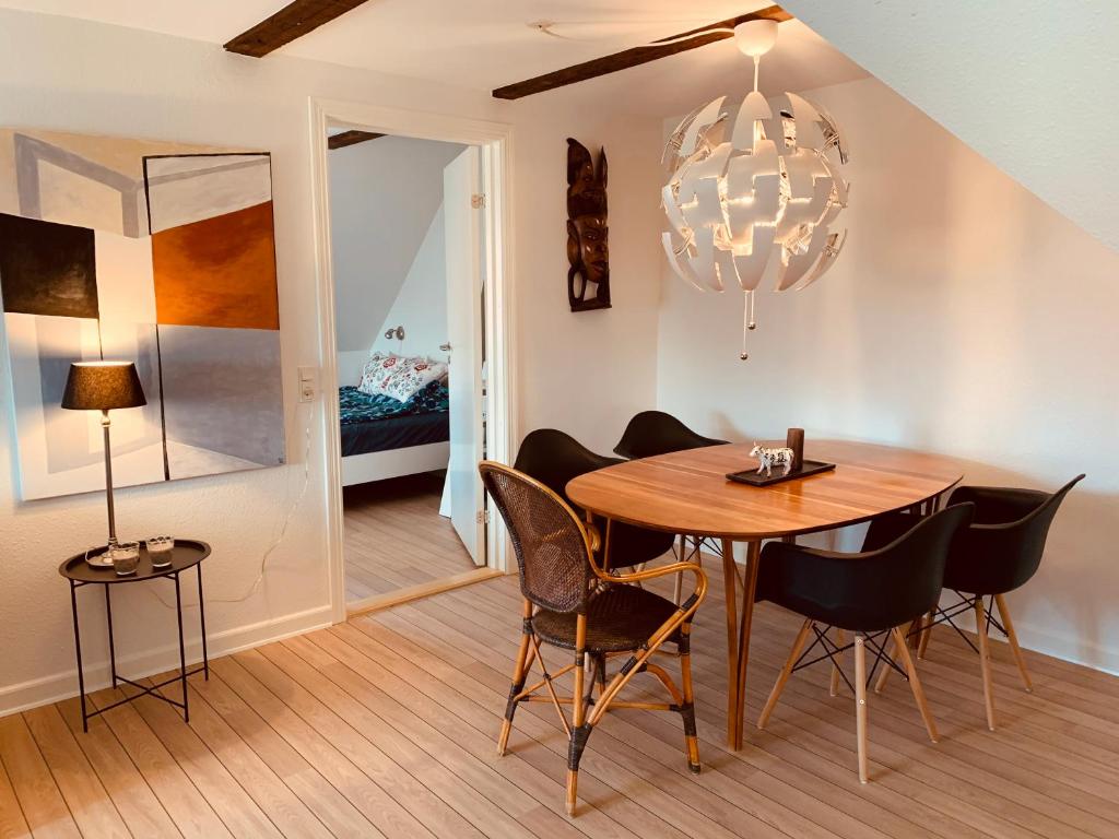 comedor con mesa, sillas y lámpara de araña en Hyggelig 1.sals lejlighed i Varde midtby. en Varde
