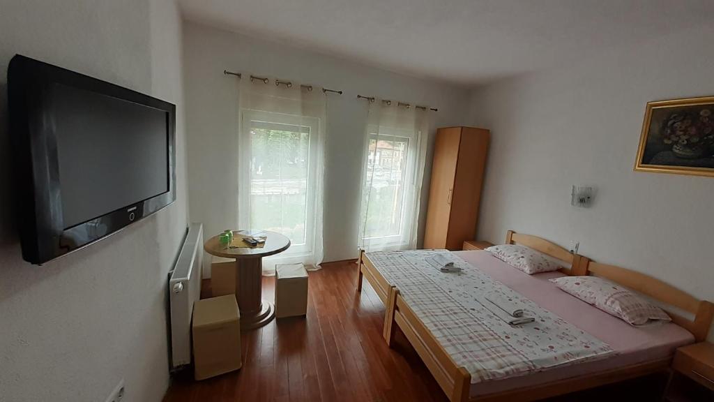 a bedroom with two beds and a flat screen tv at Prenoćište Stari Grad - Old Town in Tuzla
