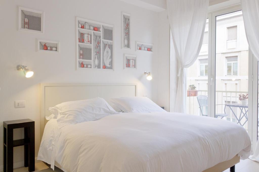 - une chambre blanche avec un lit blanc et une fenêtre dans l'établissement Domus Municipio, à Naples
