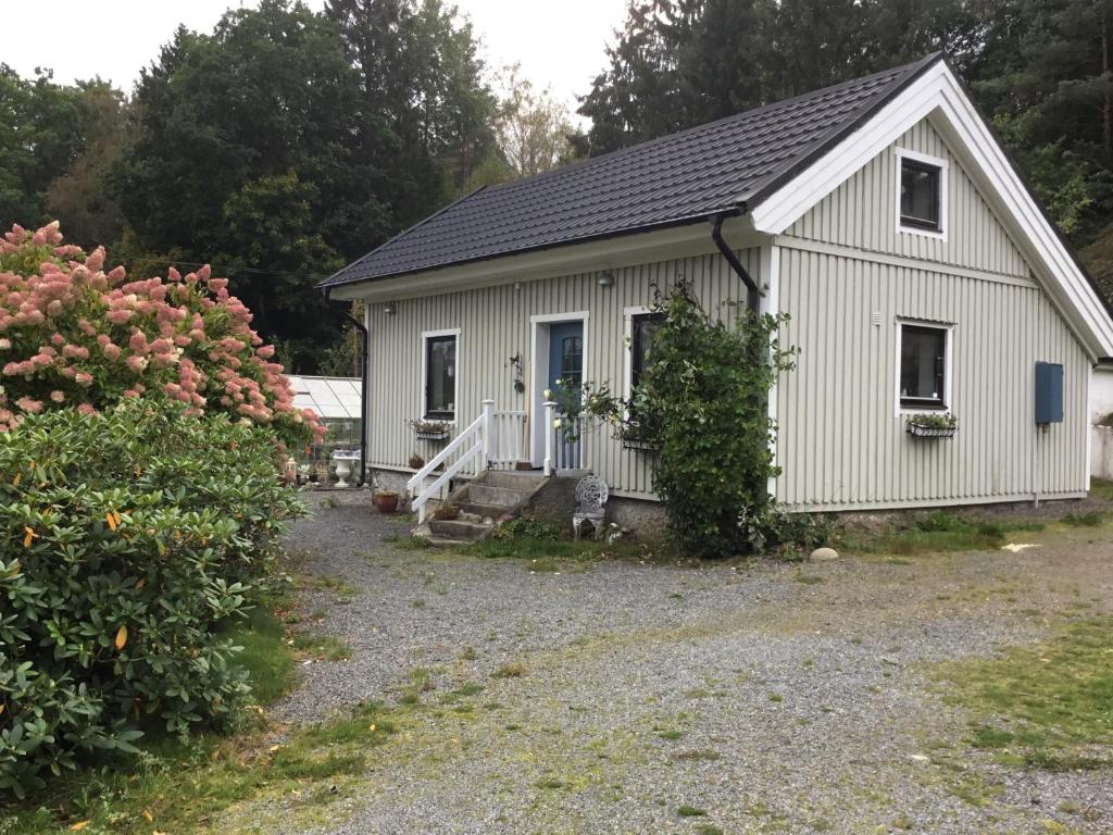 a small white building with a porch at AirbnbEkåsberg in Olofstorp