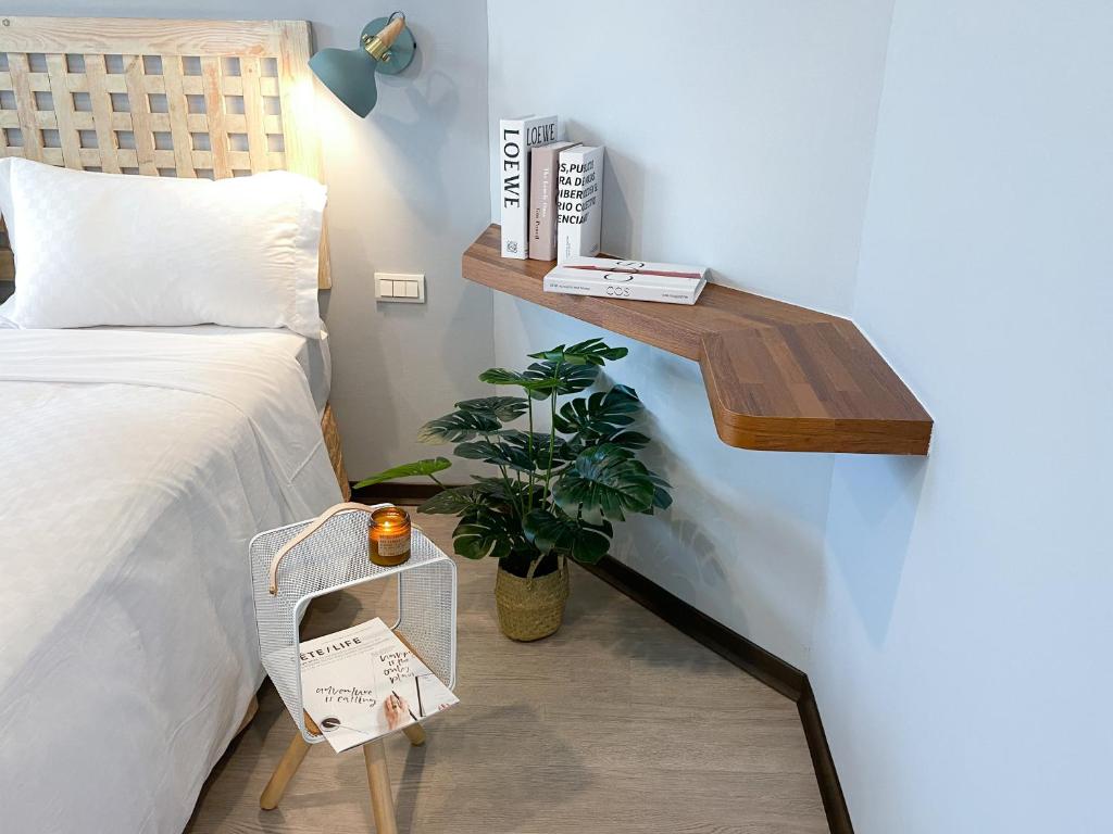 a bedroom with a bed and a shelf next to a plant at Kenting Sunhow Inn in Kenting