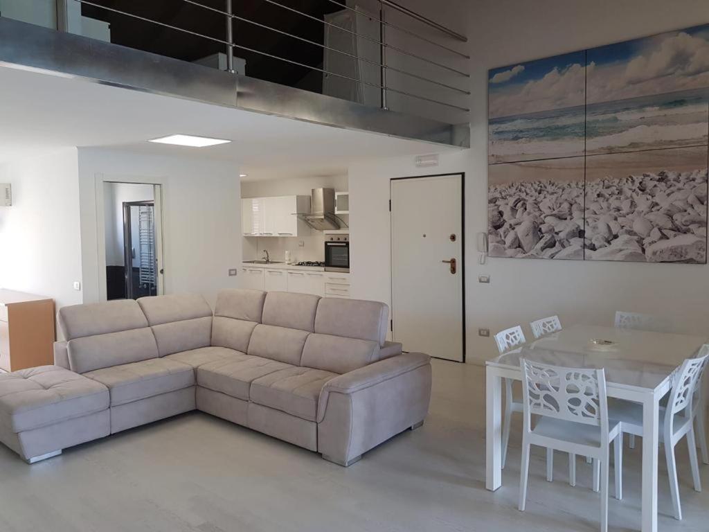salon z kanapą i stołem w obiekcie Appartamento da sogno nel Resort Marinagri w mieście Policoro
