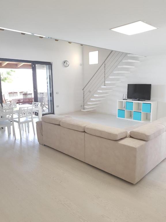 salon z dużą kanapą i schodami w obiekcie Appartamento da sogno nel Resort Marinagri w mieście Policoro