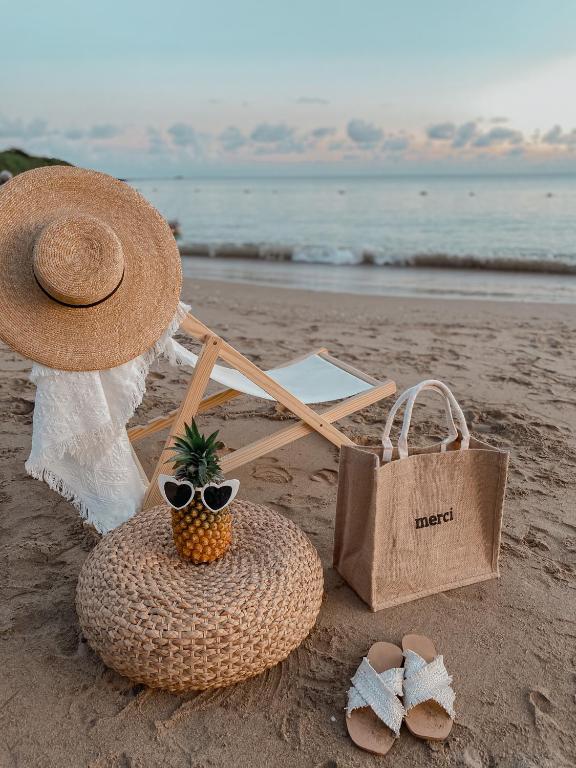 a straw hat and a basket with a pineapple on the beach at Kenting Sunhow Inn in Kenting