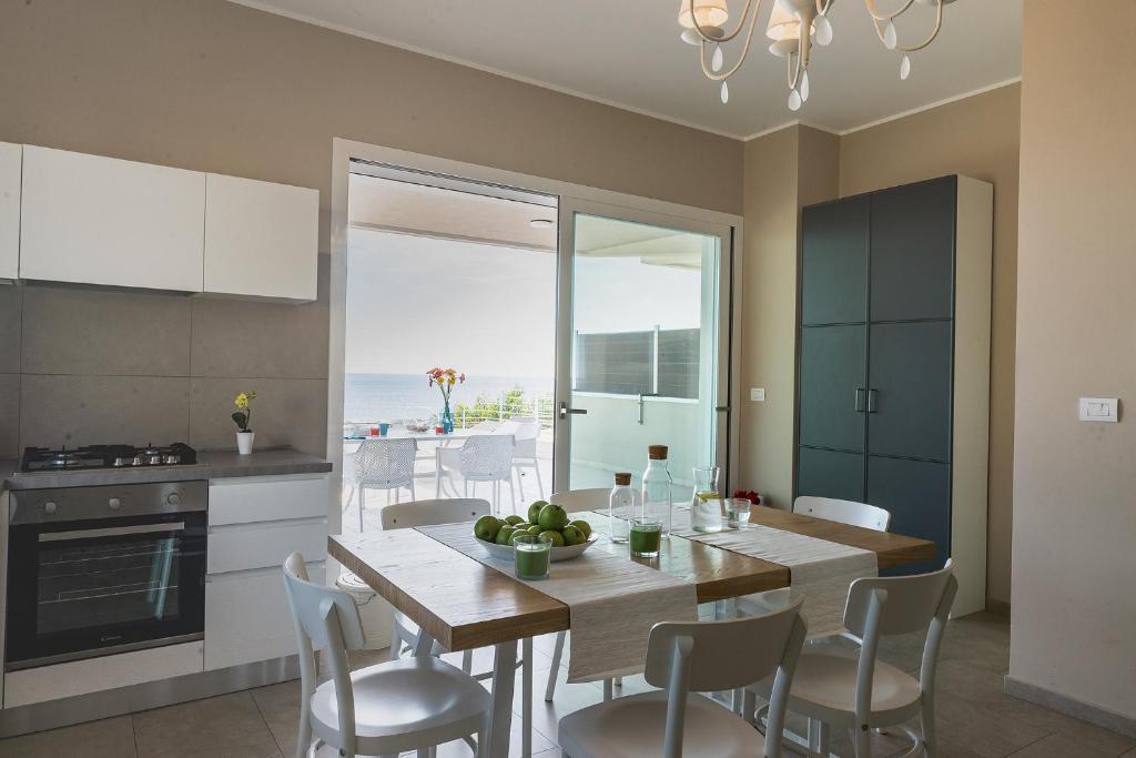 een keuken en eetkamer met een tafel en stoelen bij Cavalluccio Marino in Mazzeo