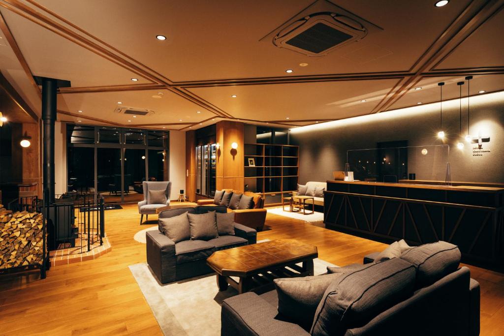 een grote woonkamer met banken en een tafel bij HOTEL KARUIZAWA CROSS in Karuizawa