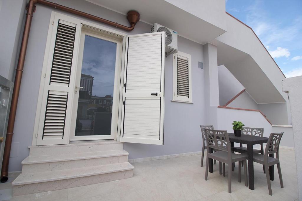 a balcony with a table and chairs and a window at Puglia casa vacanza in Ginosa Marina