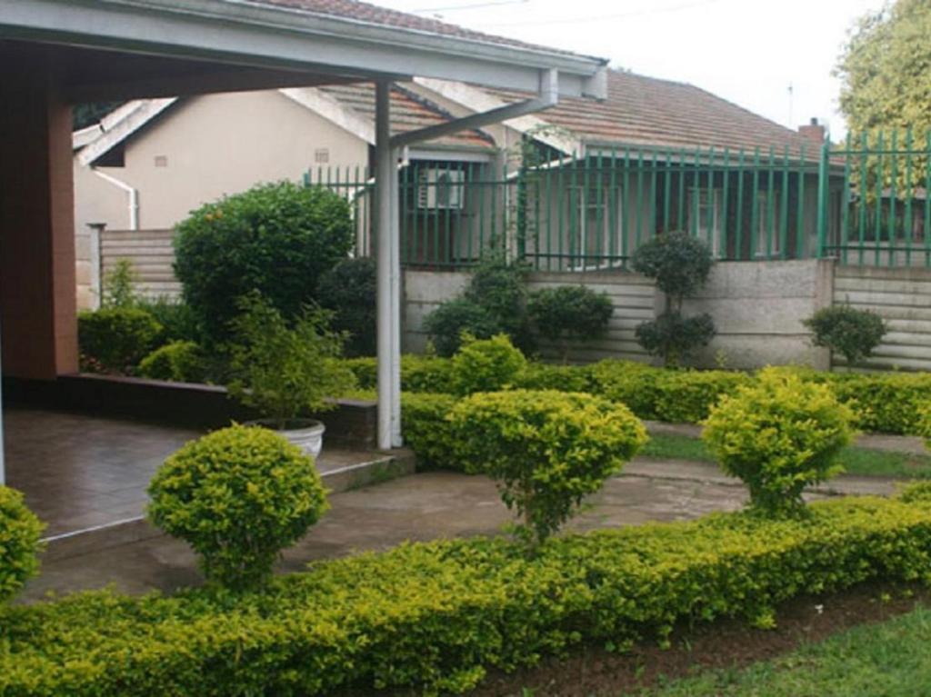 a house with a garden with bushes and trees at MS Self-Catering in Pietermaritzburg