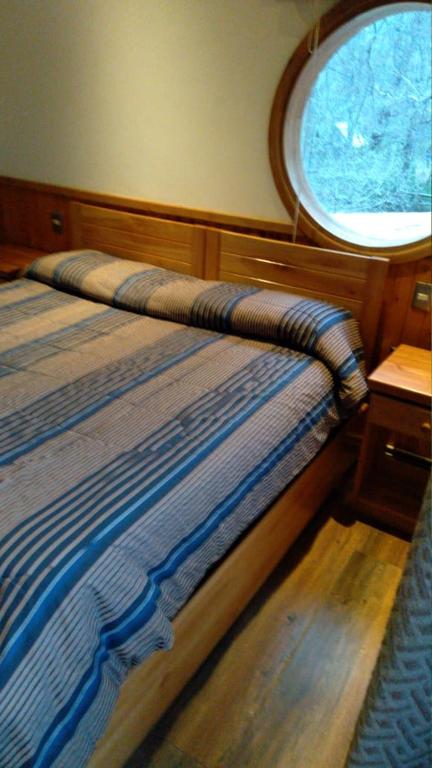 a bedroom with a bed and a window on a boat at HOTEL & HOSTAL CHIL'IN, Las Trancas in Las Trancas