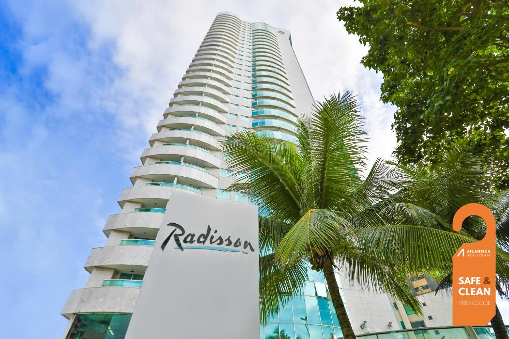een hoog gebouw met een bord ervoor bij Radisson Recife in Recife