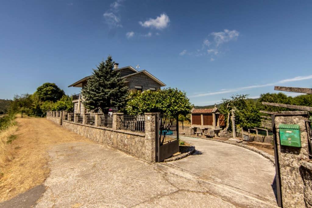 a house with a fence in front of a road at Casa Rural Picape in Pedre
