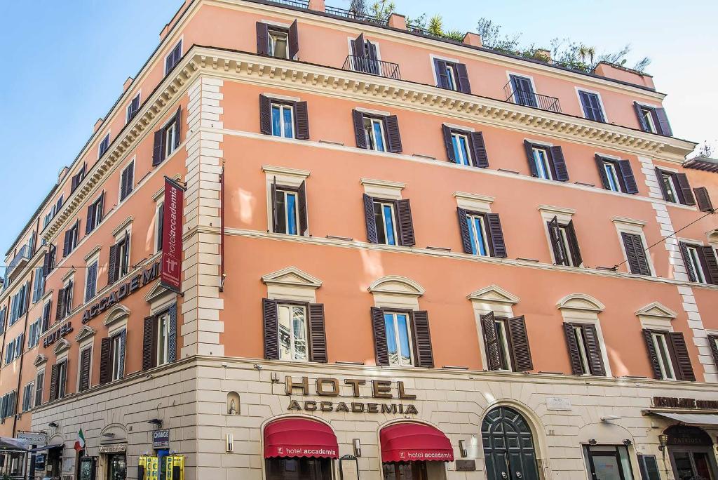 ein großes rosafarbenes Gebäude mit einem Akardium des Hotels in der Unterkunft Hotel Accademia in Rom
