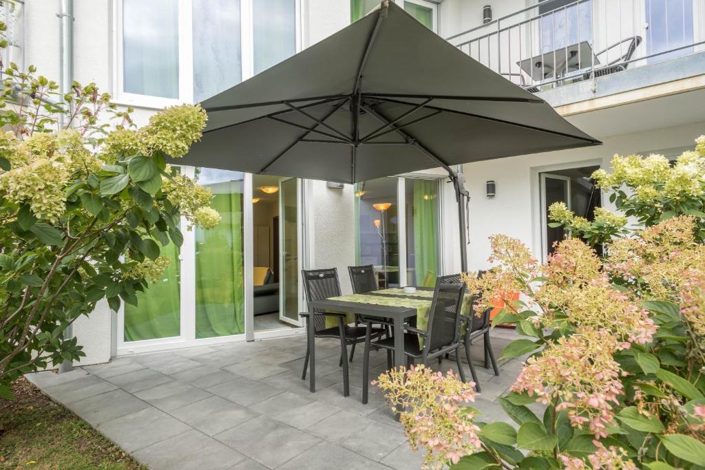 a patio with a table and chairs and an umbrella at Ferienwohnung Jasmin in Sipplingen