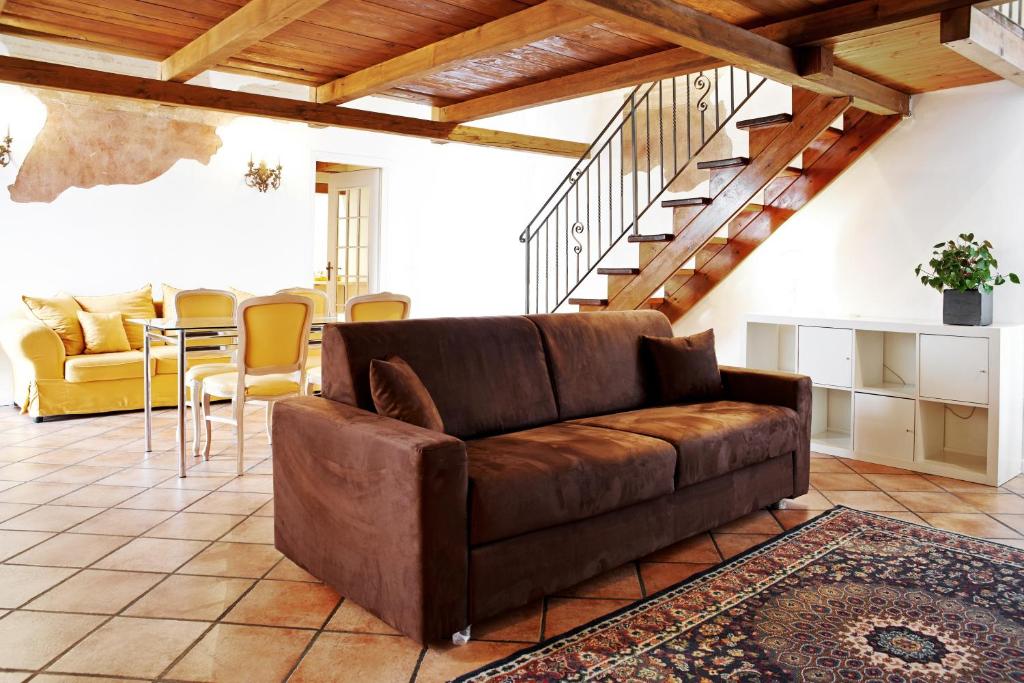 ein Wohnzimmer mit einem braunen Sofa und einem Tisch in der Unterkunft P&P Piazza Bergamo Apartment in Bergamo