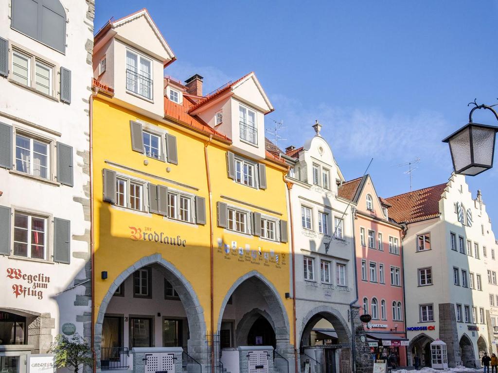 a yellow building in the middle of a group of buildings at Maximilian Apartments Lindau in Lindau