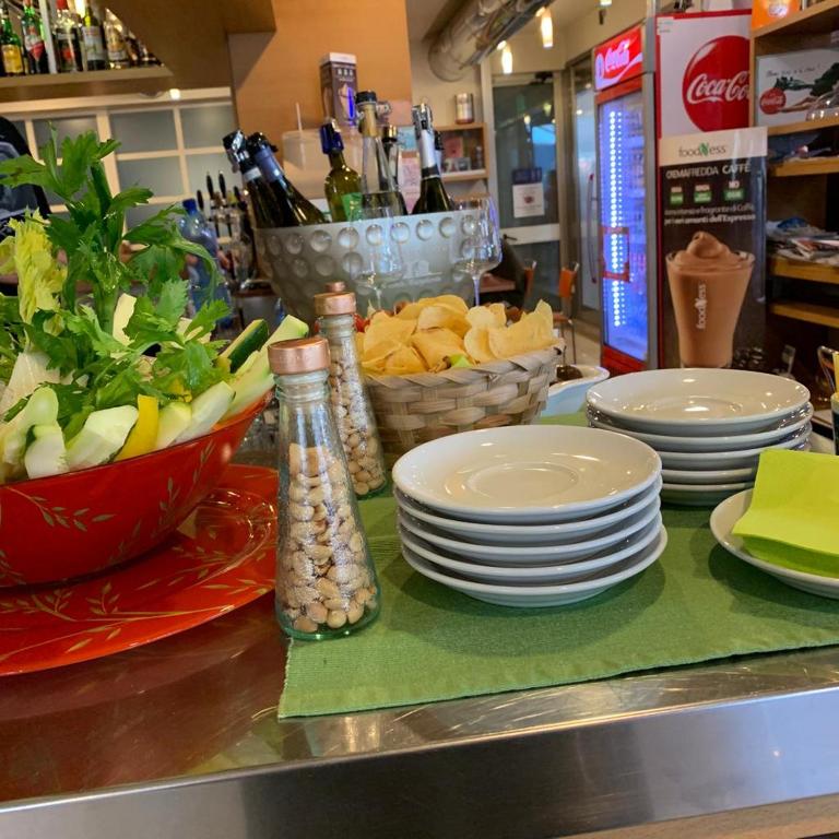 a counter with plates and bowls of food on a table at Hotel Piada D'Oro in Riccione