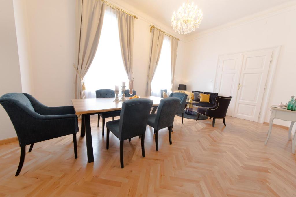 a dining room with a table and chairs and a chandelier at Palais Gutenberg la Ville in Klagenfurt